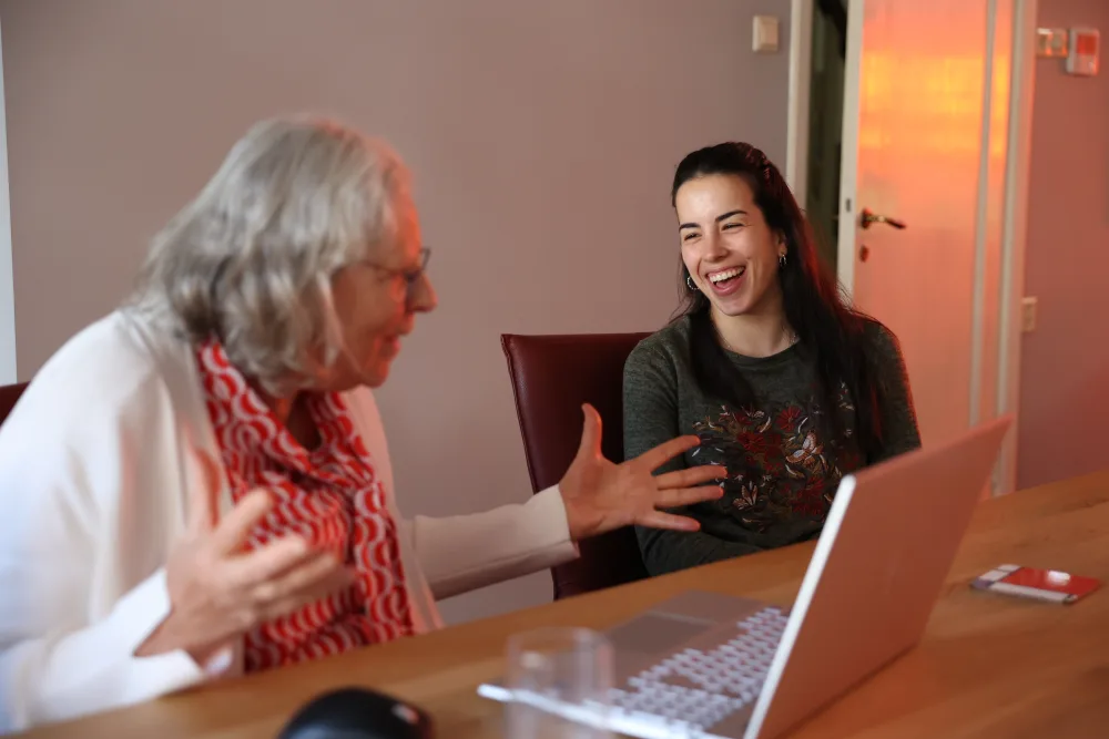 Een host en huurder in gesprek achter een laptop