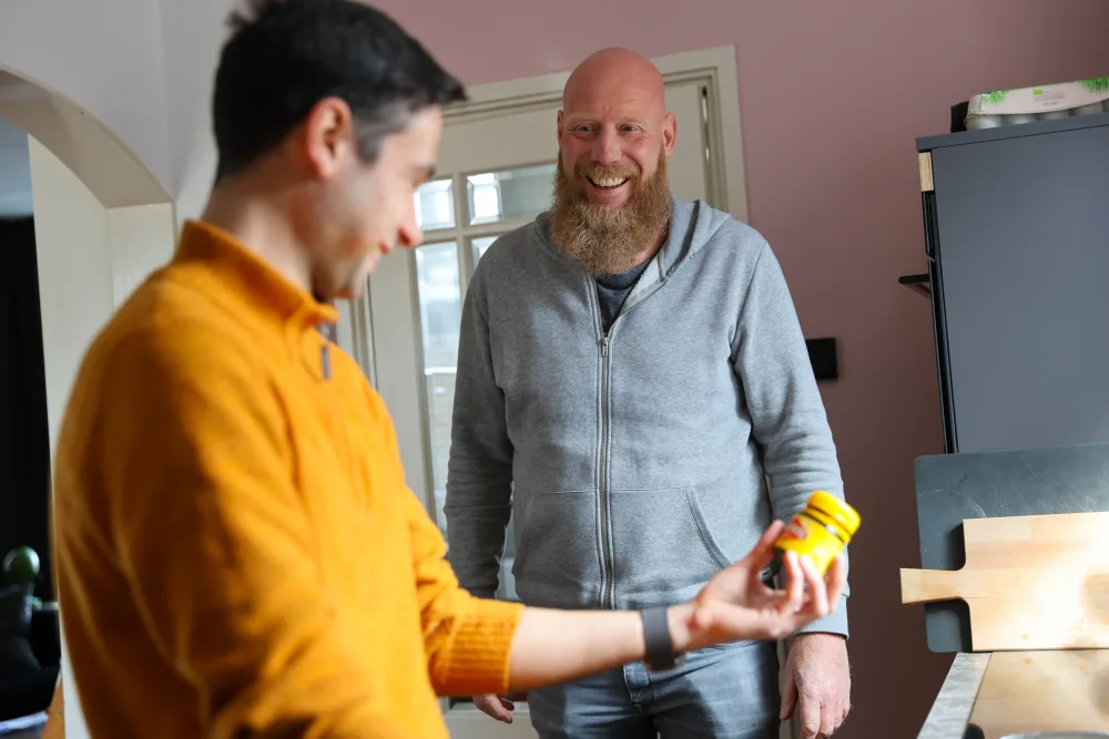 Twee huisgenoten bespreken iets in de keuken