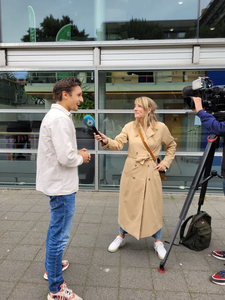 Een woordvoerder van Hospi Housing wordt buiten geïnterviewd door een cameraploeg