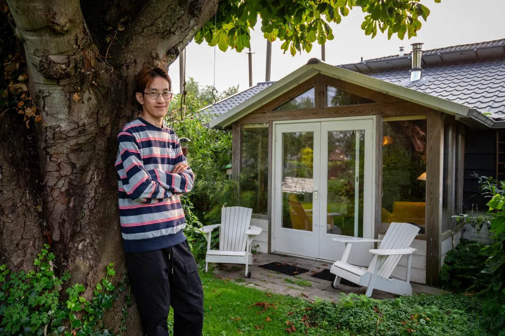 Een huurder in de tuin bij zijn kamer